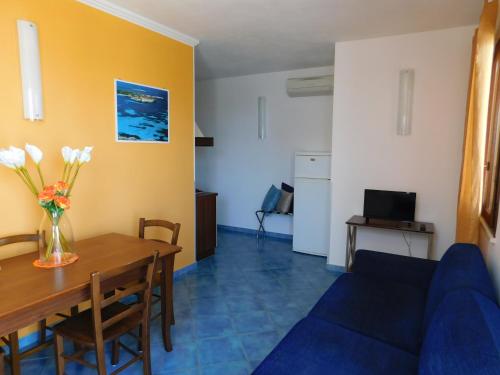 uma sala de estar com uma mesa e um sofá azul em Case Vacanza Elisir em Favignana