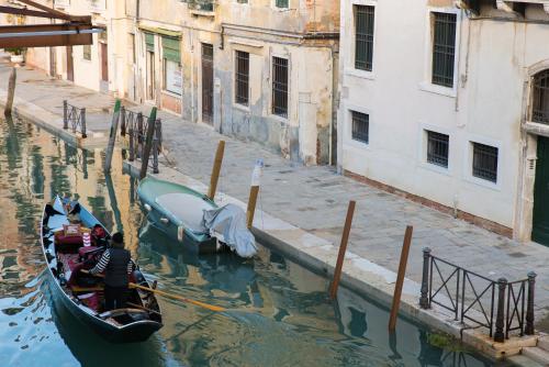 a gondola is docked in a canal next to buildings at Al Mascaron Ridente in Venice