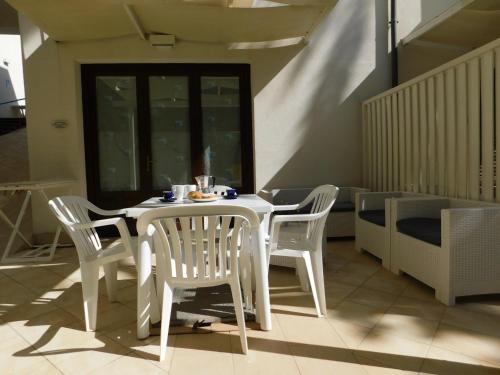 a white table and chairs in a room at Case Vacanza Elisir in Favignana