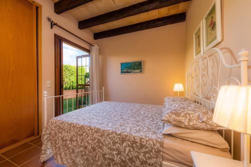 a bedroom with a bed and a large window at Estrella in Son Serra de Marina
