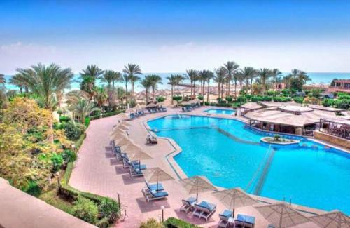 an aerial view of a resort pool with palm trees at قرية بالميرا العين السخنة in Ain Sokhna