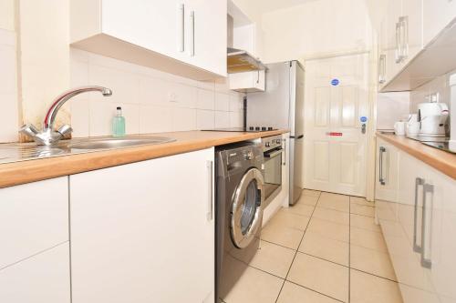 a white kitchen with a washing machine in it at Townhouse @ 178 Ruskin Road Crewe in Crewe