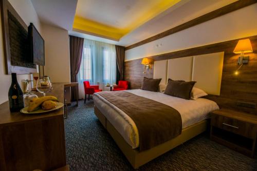 SarıkamısにあるSarikamis Habitat Hotelのベッドとデスクが備わるホテルルームと