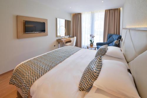 a hotel room with a bed and a tv at Mediteran Hotel & Resort in Budva