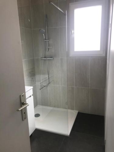 une salle de bain avec une douche avec une porte vitrée dans l'établissement Confort et calme à deux pas des plages de Valras, à Valras-Plage