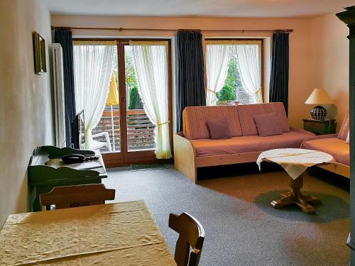 a living room with a couch and a table at Gästehaus zur Färbe Apartments in Oberstdorf