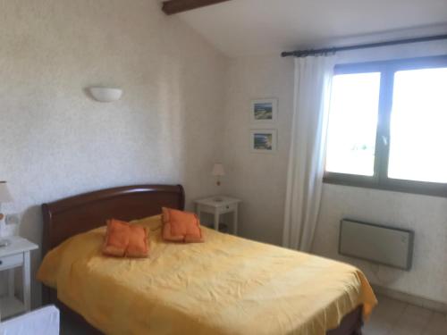 - une chambre dotée d'un lit avec des oreillers orange dans l'établissement Confort et calme à deux pas des plages de Valras, à Valras-Plage