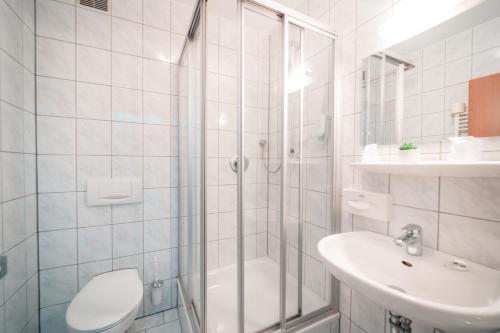 ein Badezimmer mit Dusche, Toilette und Waschbecken in der Unterkunft Airport Lounge Hotel Düsseldorf in Düsseldorf