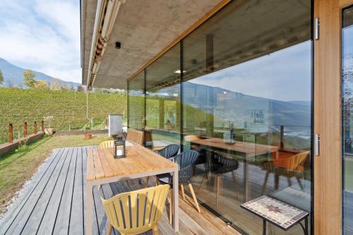 a glass house with a table and chairs on a deck at Villa Vogelnest in Bressanone