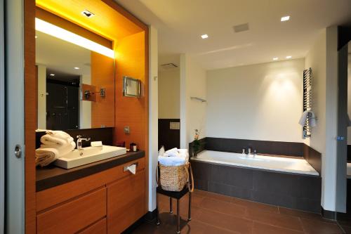 a bathroom with a tub and a sink and a bath tub at Schlossgut Gross Schwansee in Groß Schwansee