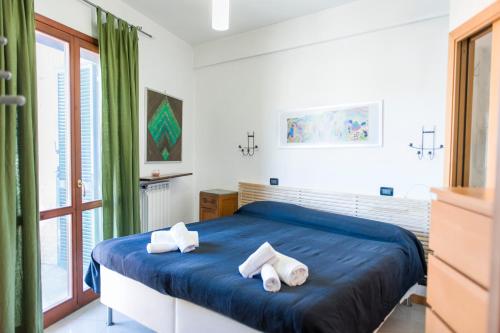 Un dormitorio con una cama azul con toallas. en Flatinrome Residence Fiera, en Ponte Galeria