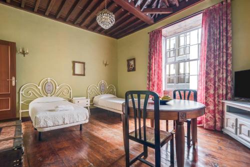 Habitación con mesa, cama y ventana en La Vicaría, en La Laguna