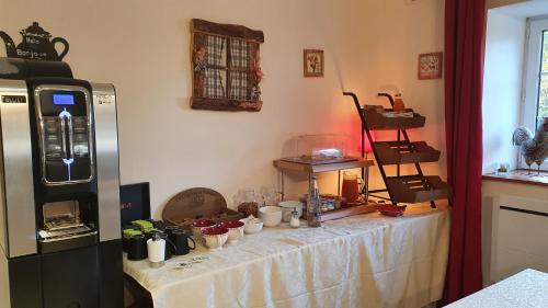 een keuken met een tafel met kopjes erop bij Le Relais de la Comté in Portbail