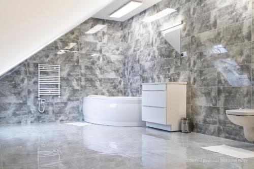ein Badezimmer mit einer weißen Badewanne und einem Waschbecken in der Unterkunft Dom u podnóża Biskupiej Kopy in Jarnołtówek
