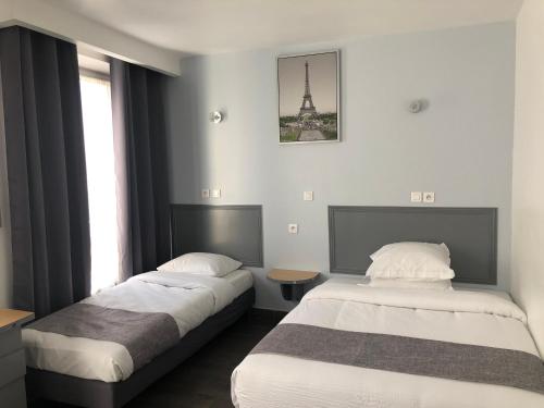 - 2 lits dans une chambre d'hôtel avec la tour Eiffel dans l'établissement Hôtel Clauzel Paris, à Paris