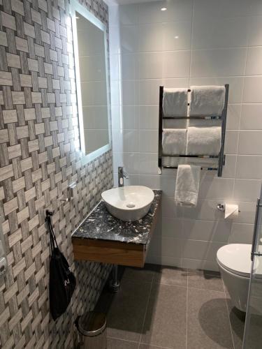 a bathroom with a toilet, sink, and tub at ProfilHotels Central in Stockholm