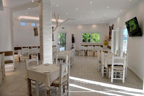 a dining room with white tables and white chairs at Piccolo Hotel Luisa in Ponza