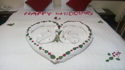 a cake in the shape of a heart on a bed at New Charity Hotel International in Arusha