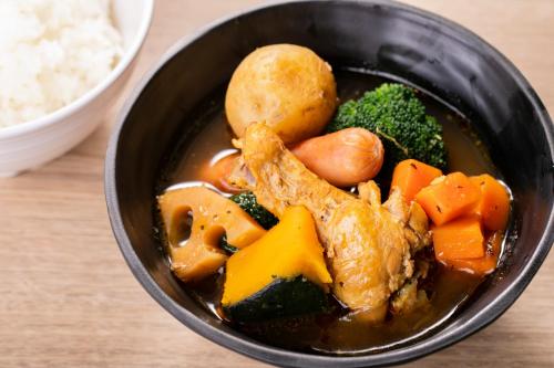 a bowl of soup with meat and vegetables and rice at Hotel Wing International Sapporo Susukino in Sapporo