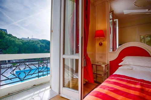 a bedroom with a balcony with a bed and a window at Grand Hotel Des Bains in Riccione