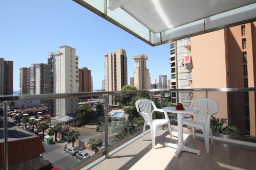 a balcony with a table and two chairs and a city at Hotel Perla in Benidorm