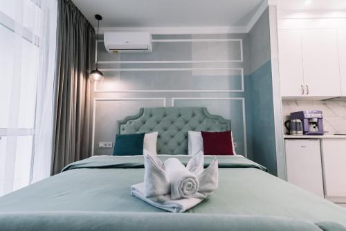 een slaapkamer met een bed met een blauw hoofdeinde en kussens bij Royal Tower VIP Smart Apartments 1 in Kiev