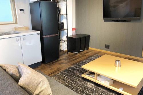 a living room with a couch and a coffee table at Chill Inn Honan in Tokyo