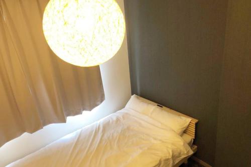 a bed in a room with a window at Chill Inn Honan in Tokyo
