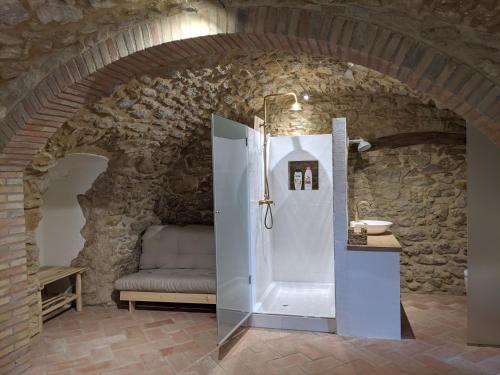 a bathroom with a shower in a stone wall at Can Puig CAVE in La Pera