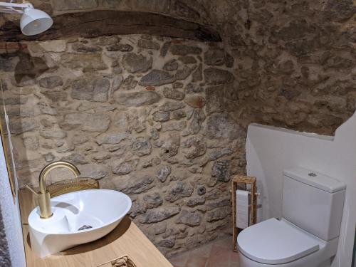 a stone bathroom with a sink and a toilet at Can Puig CAVE in La Pera