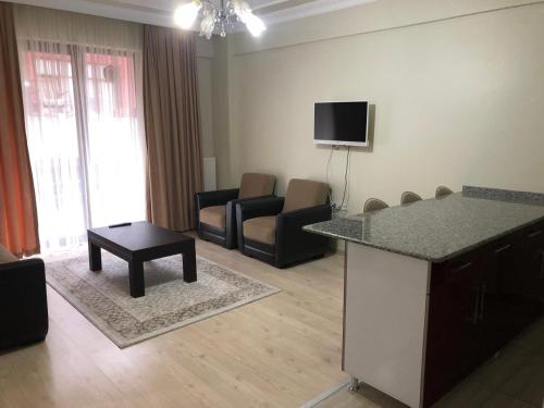 a living room with a kitchen and a living room with chairs at Almasa Suite Aparts in Termal