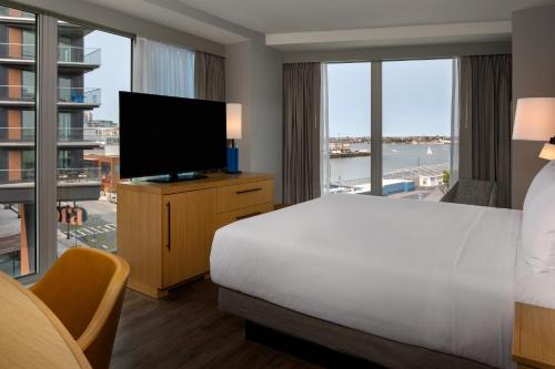 a hotel room with a bed and a flat screen tv at Hyatt Place Boston/Seaport District in Boston