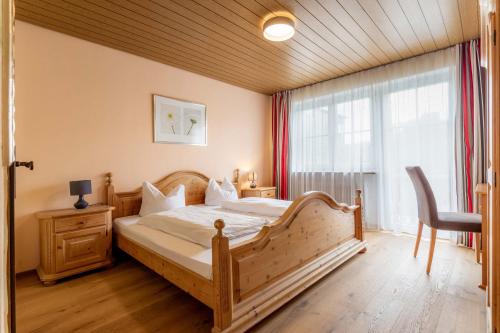 
a bedroom with a large bed and a large window at Landgasthof Moser & Restaurant Bootshaus in Windorf
