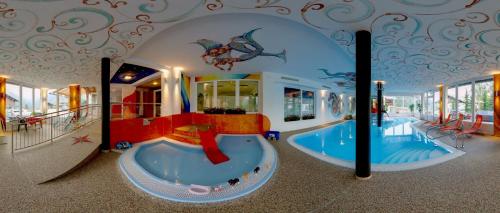 een overdekt waterpark met een zwembad bij Hotel-Gasthof Andreas in Obertilliach