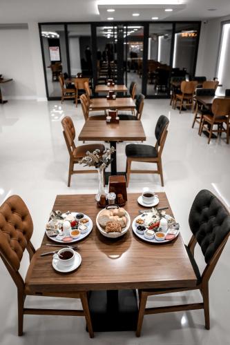 a row of wooden tables with plates of food on them at Dimen Hotel in Bursa
