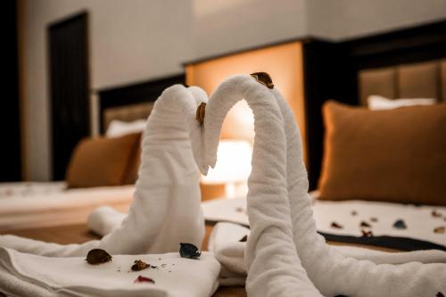 two towel swans sitting on a table in a hotel room at Dimen Hotel in Bursa