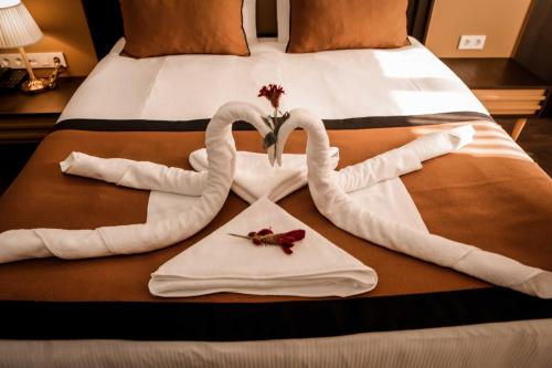 a bed with two swans made out of towels at Dimen Hotel in Bursa