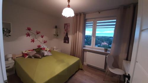 1 dormitorio con mesa verde y ventana en Apartament Pełka en Varsovia