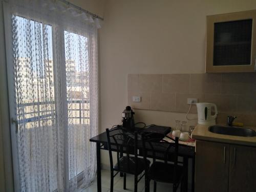 a kitchen with a table and chairs next to a window at Studio Apartment at Tiba Star in Hurghada