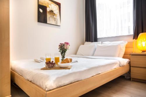 a bed with a tray of food and drinks on it at Center Design Residence in Brussels
