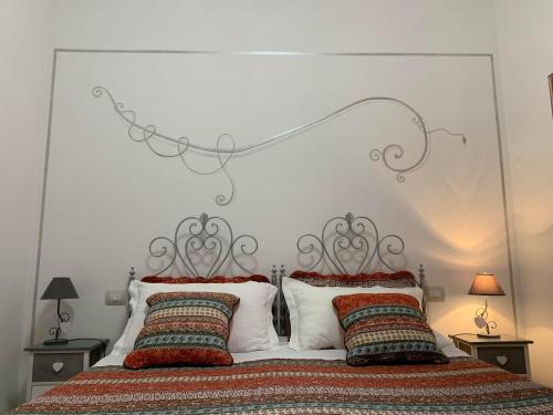 a bedroom with a large white bed with two pillows at Atmosfera d'Arte - Private parking in Orvieto