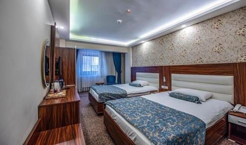een hotelkamer met 2 bedden en een televisie bij Madi otel in Konak