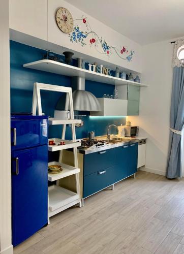 a kitchen with blue cabinets and a white shelf at Atmosfera d'Arte - Private parking in Orvieto