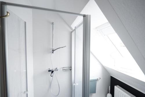 a bathroom with a shower with a glass door at Hotel Wurster Kroog in Bremerhaven