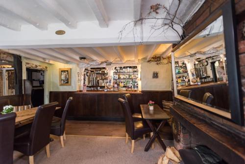 a restaurant with a table and chairs and a bar at Golden Lion Hotel in Rugby