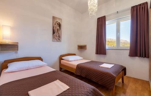 two beds in a room with a window at Luxury villa Liberta near Split, private pool in Podstrana