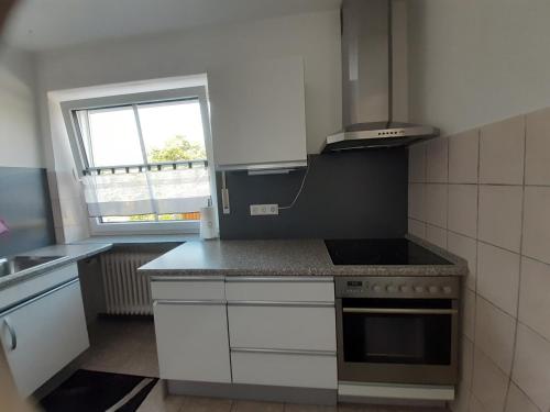 a kitchen with white cabinets and a stove top oven at Ferienwohnung Leibl in Oberviechtach