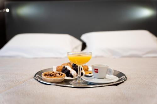 a tray of food and a glass of orange juice and coffee at Hotel Victoria in Cuneo