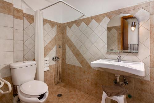 a bathroom with a toilet and a sink at Zampakas Hotel Panorama in Stournaraíïka