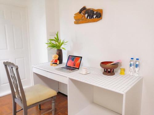 a white desk with a laptop and a chair at Near old city,Nimman,night Bazaar swimming pool apartment 25 in Chiang Mai
